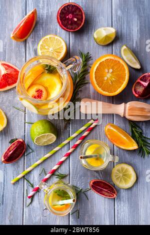 Limonata fresca fatta in casa con agrumi a fette su uno sfondo grigio di legno.Vista dall'alto piatto spazio copia sfondo di frutta fresca sana. Foto Stock