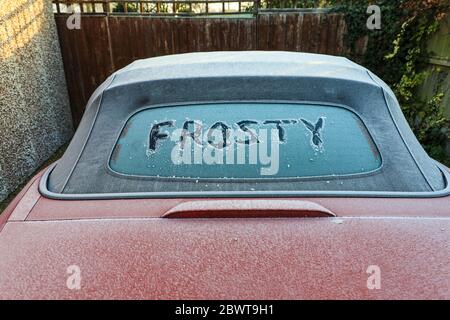 La parola gelata scritta sul lunotto di un'auto coperta da ghiaccio, Inghilterra, Regno Unito Foto Stock