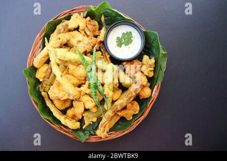 Pakode misto o bhajiya, Pakodi, Bhaji è fresco fritto snack piccante fatto con verdure come peperoncino, cipolla, patate, frutti di presa crudi. Foto Stock