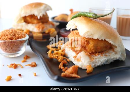 Vada pav o wada pao è un piatto vegetariano di fast food originario dello stato del Maharashtra. Famoso cibo di strada di Mumbai servito con chutney rosso. Foto Stock