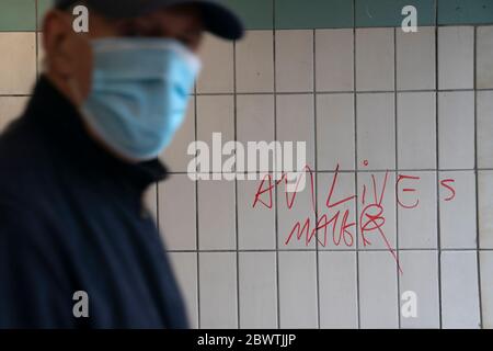 Manchester, Regno Unito. 3 Giugno 2020. Un membro del pubblico cammina davanti ai graffiti "All Lives Matter" a Bury, vicino a Manchester, mentre le proteste della materia Black Lives sono viste in tutto il mondo dopo la morte nella custodia della polizia di George Floyd a Minneapolis, Manchester, Regno Unito. Credit: Jon Super/Alamy Live News. Foto Stock