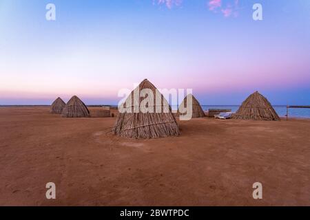 Egitto, Hurghada, rifugi sulla spiaggia sabbiosa di Sahl Hasheesh Bay all'alba Foto Stock