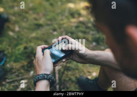 Giovane uomo che controlla il dispositivo di navigazione Foto Stock
