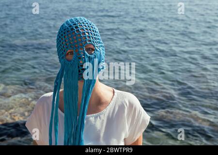 Ritratto di donna che indossa un ricchino blu con frange di fronte al mare Foto Stock
