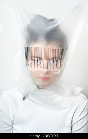 Ritratto di giovane donna che indossa una maschera trasparente con codice a barre Foto Stock
