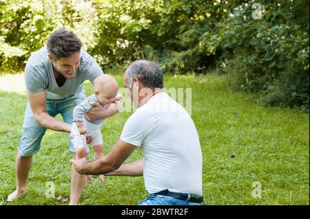 Uomo anziano che passa il tempo con il figlio adulto e la nipote in un parco Foto Stock