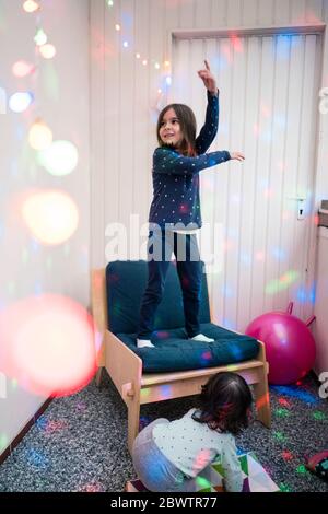 Ragazze felici che hanno una festa circondata da luci da discoteca Foto Stock