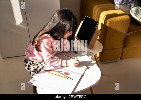 Ragazza che fa i compiti nel soggiorno Foto Stock