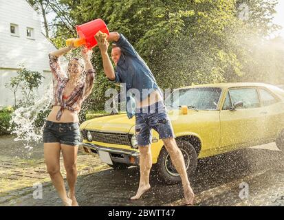 Amici lavaggio auto giallo vintage in estate divertirsi Foto Stock