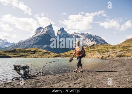 Escursionista in paesaggio montano sul lago nel Parco Nazionale Torres del Paine, Patagonia, Cile Foto Stock