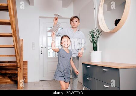 Fratello e sorella giocano con aerei di carta Foto Stock