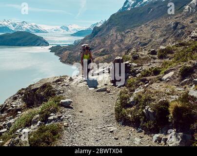 Donna con il suo zaino facendo un trekking in montagna, Parque Nacional Torres del Paine, Cile Foto Stock