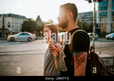 Felice giovane coppia che cammina in città, Berlino, Germania Foto Stock