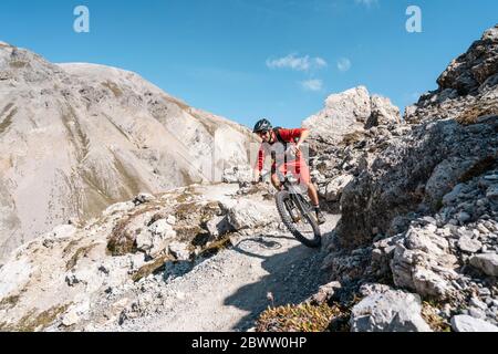 Uomo in mountain bike, Valle Munestertal, Grigioni, Svizzera Foto Stock