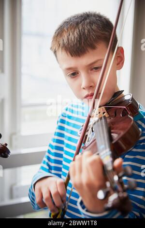 Ragazzo che suona violino durante una lezione Foto Stock