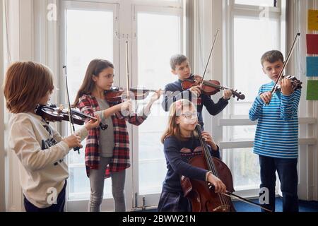 Gruppo di bambini che suonano violino durante una lezione Foto Stock