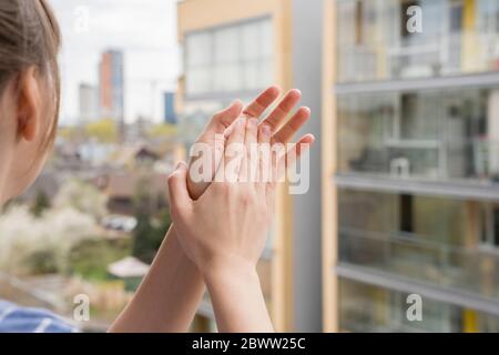 Vista di ritaglio di donna che si aggrappano le mani sul balcone Foto Stock