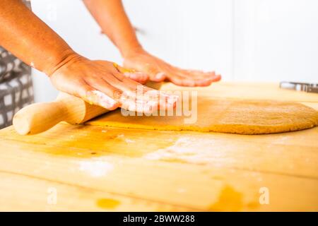 Donna che si stende fuori l'impasto per una torta Foto Stock