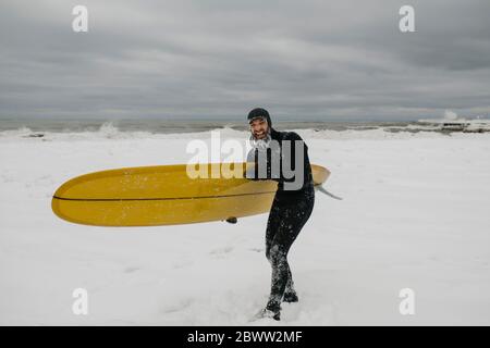 Surfista con tavola da surf nella neve in Ontario, Canada Foto Stock