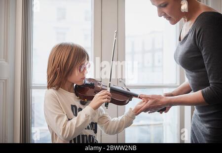 Insegnante che insegna al ragazzo che suona violino durante una lezione Foto Stock