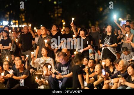 Una folla che riflette durante una Veglia a lume di candela per le vittime del massacro di Piazza Tiananmen a Victoria Park, Hong Kong - 4 giugno 2019 Foto Stock