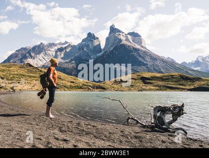 Escursionista in paesaggio montano sul lago nel Parco Nazionale Torres del Paine, Patagonia, Cile Foto Stock