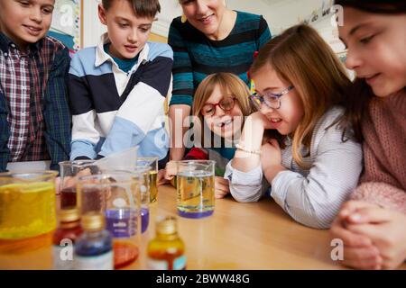 Gruppo di bambini con insegnante in una lezione di chimica scientifica Foto Stock