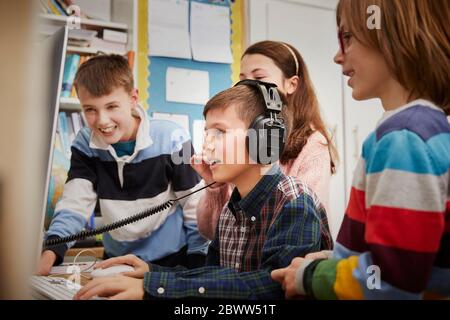 Bambini che giocano su un computer in classe Foto Stock