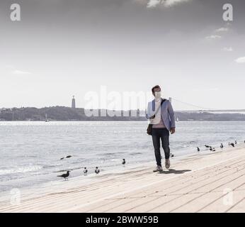 Giovane uomo che cammina sul lungomare Foto Stock