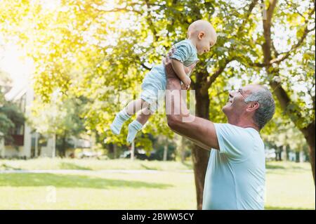 Uomo anziano che passa il tempo con sua nipote in un parco Foto Stock