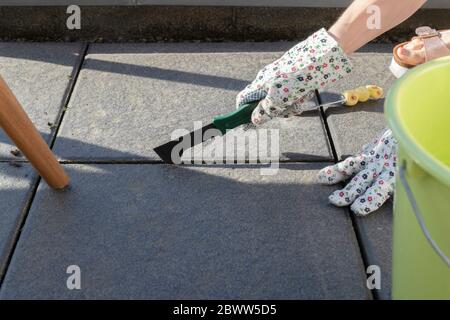Germania, mani di donna che indossano guanti protettivi che lavorano sul balcone Foto Stock