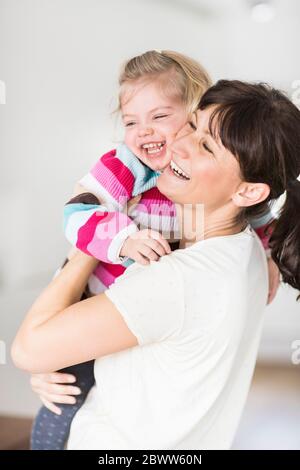 Madre ridente che tiene la figlia Foto Stock
