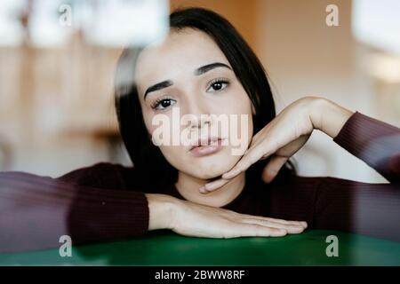 Ritratto di giovane donna dietro il vetro di finestra Foto Stock