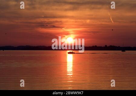 Germania, Bavria, Lago Chiemsee, Silhouette di barca a vela solista al tramonto Foto Stock
