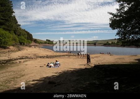 Turisti e residenti godono di sole estivo ai margini del Digley Reservoir, nel West Yorkshire, sotto il cielo blu Foto Stock