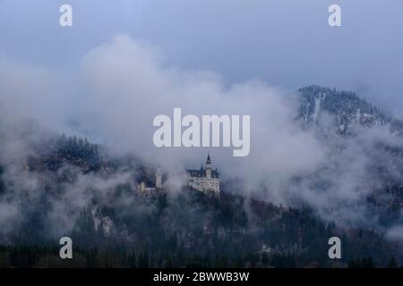 Germania, Baviera, Hohenschwangau, veduta aerea del Castello di Neuschwanstein avvolta dalla nebbia Foto Stock