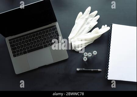 Direttamente sopra la ripresa di campioni medici con guanti e notebook a spirale da portatile sul tavolo Foto Stock