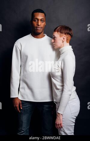 Studio ritratto di coppia mista da corsa con pullover bianchi Foto Stock