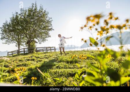 Donna spensierata che danzava su un prato in montagna, Achenkirch, Austria Foto Stock