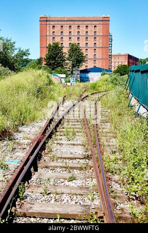 Old Railway Tracks che conduce ad un magazzino vittoriano disusato a Bristol, Inghilterra Regno Unito Foto Stock