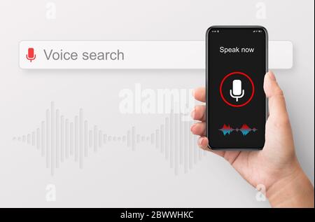 Donna che tiene in mano lo smartphone utilizzando la ricerca vocale, sfondo bianco Foto Stock
