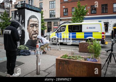 Manchester, Regno Unito. 03 giugno 2020. La polizia passa davanti al Street artist Akse P19, che mette i tocchi finali al murale di George Floyd. Credit: SOPA Images Limited/Alamy Live News Foto Stock