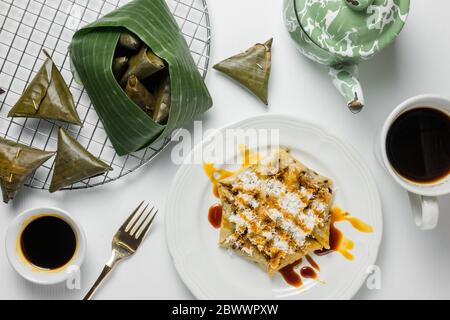 Torta lupi, uno spuntino tradizionale indonesiano a base di riso appiccicoso. Servito con cocco grattugiato e zucchero di canna. Foto Stock