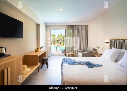 Interni in legno chiaro e a strisce beige di stile moderno minimalista con finestra a vista e piscina tropicale Foto Stock