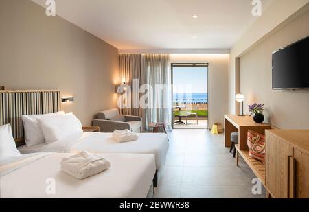 Interni in legno chiaro e a strisce beige di stile moderno minimalista, con finestre aperte e vista mare Foto Stock