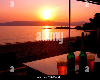 Skiathos, Grecia, 26 maggio 2006. Glorioso tramonto sul mare e sulla spiaggia da una taverna sulla spiaggia di Agia Eleni a Skiathos in Grecia. Foto Stock