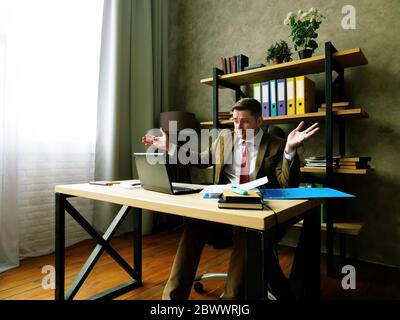 Uomo d'affari sconvolto e deluso legge il rapporto nel portatile. Problemi con il concetto di affari. Foto Stock