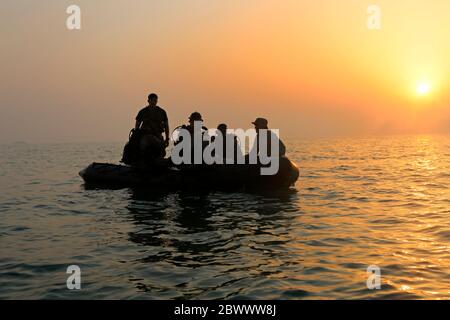 I Marines statunitensi assegnati alla Maritime RAID Force, 26a unità di spedizione marina, si preparano a immergersi al tramonto da un'imbarcazione in gomma durante l'addestramento di supporto 25 maggio 2020 nel Golfo Arabico. Foto Stock