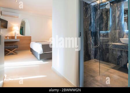 Interni moderni di colore grigio con camera da letto in legno e bagno in marmo in camera d'appartamento dell'hotel con spazio per la copia a parete vuota Foto Stock