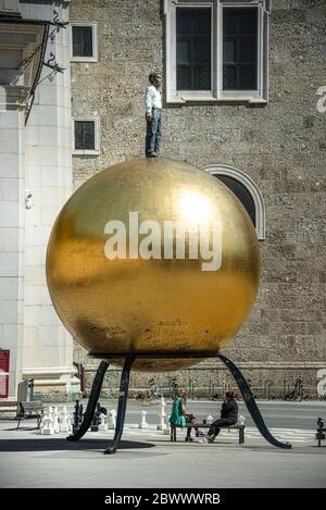 Piazza Kapitelplatz con Stephan Balkenhol - Sphaera, una scultura di un uomo su una sfera d'oro e scacchi giganti nella città vecchia di Salisburgo, Austria Foto Stock